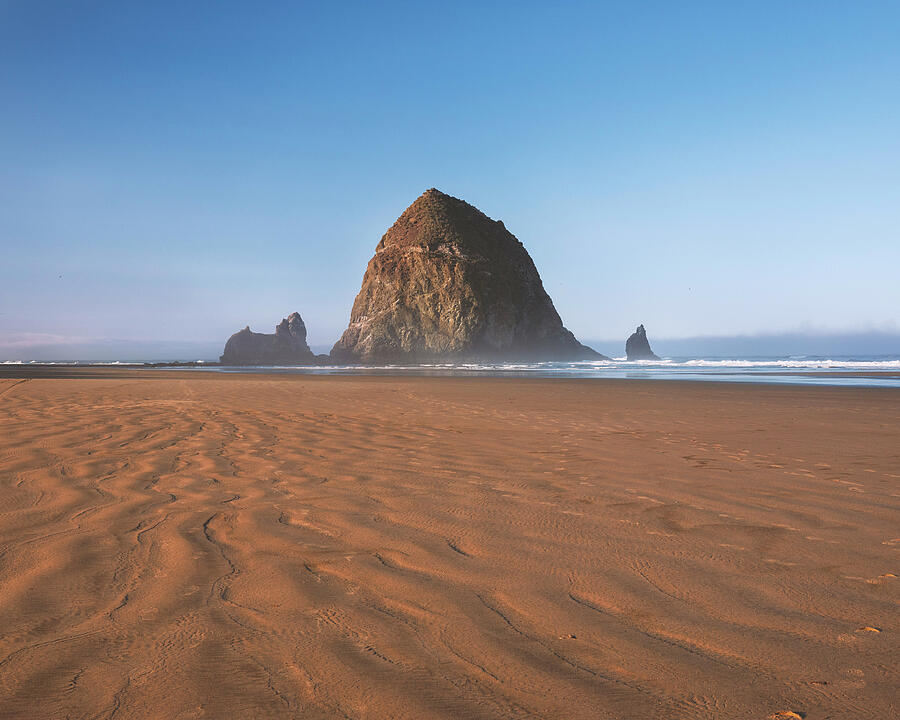 Haystack Rock on Cannon Beach beneath a clear autumn sky